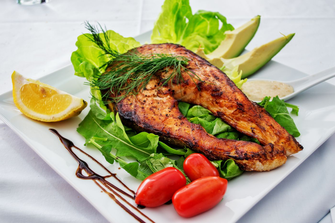 Gegrilde vis met verse salade, citroen en avocado